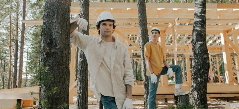 Two men building a house in the woods.