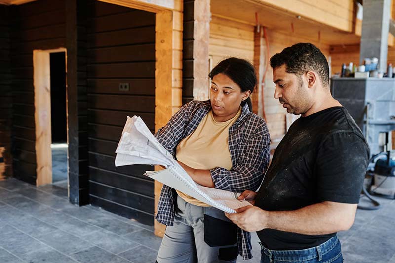 A man and woman looking at the construction plan